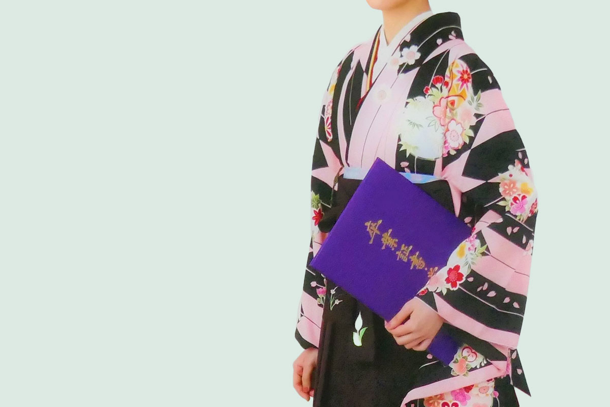 矢羽柄の二尺袖着物に紫の袴をあわせた着物を着た女性